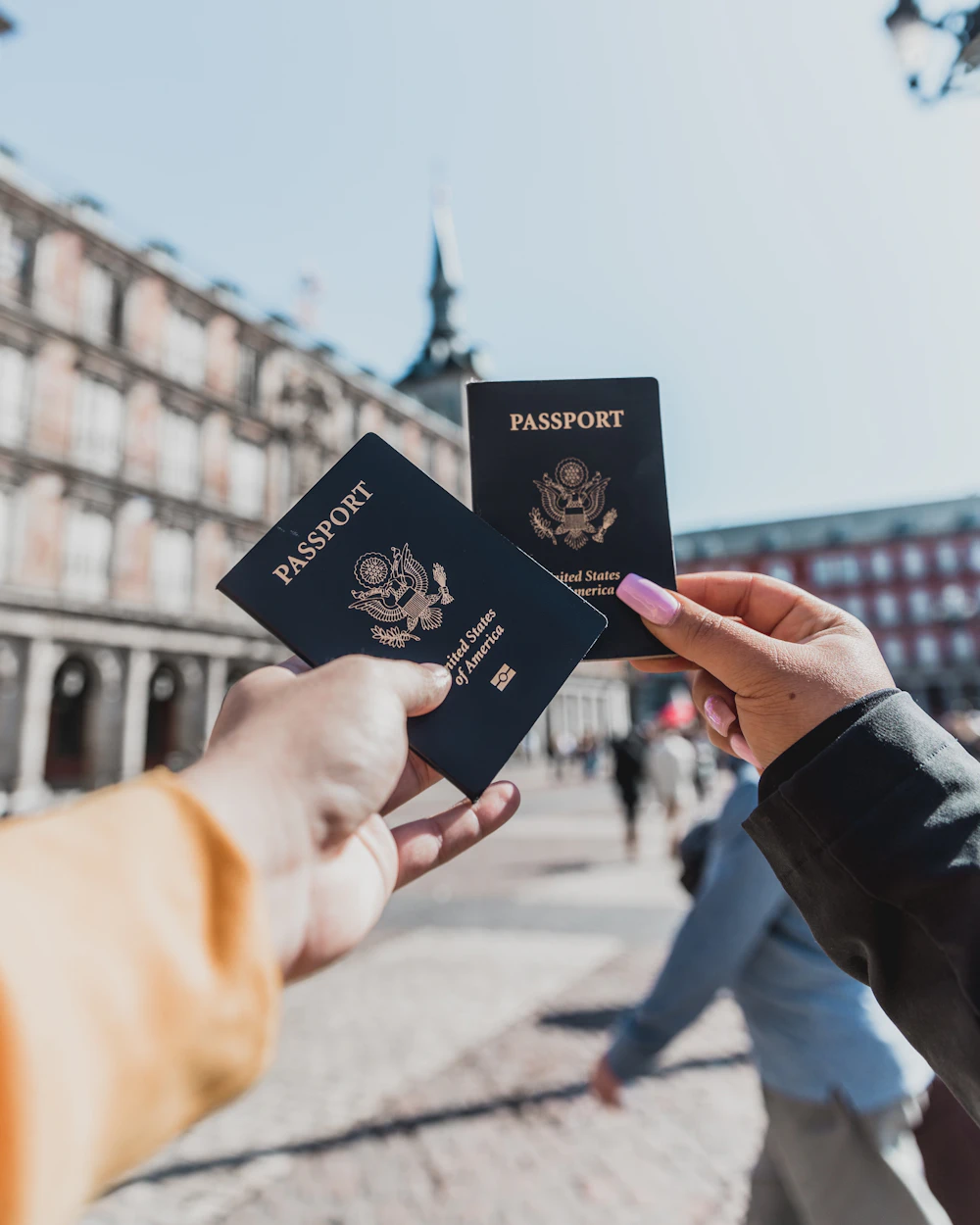 Dos personas sostienen sus pasaportes